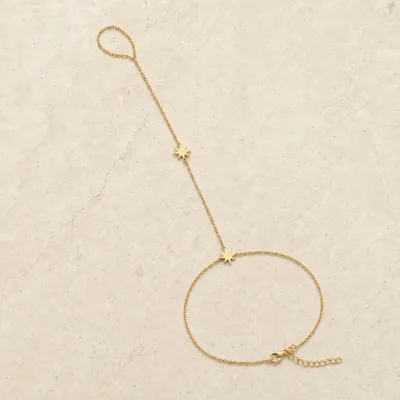 pulseira de mão dourada com duas estrelas de oito pontas em pedra clara de tom quente, referência 85476-2