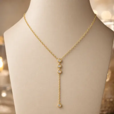 Detalhe do colar dourado em Y com cristais