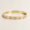 bracelete liso com cinco cristais quadrados, variante dourada, pedra clara, referência 85580-2