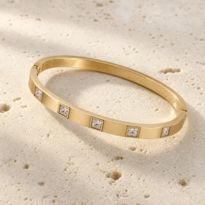 bracelete liso com cinco cristais quadrados, variante dourada, pedra clara, referência 85580-2