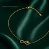 Colar infinito com coração dourado em fundo verde acetinado