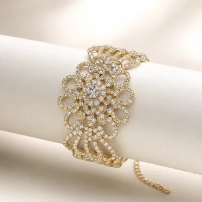 Pulseira larga floral dourada apresentada sobre suporte neutro