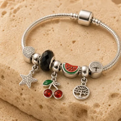 Pulseira Prateada de Aço com Berloques de Cereja Preta sobre pedra quente