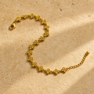 Pulseira Dourada com Flores de Cristal Amarelo sobre pedra quente
