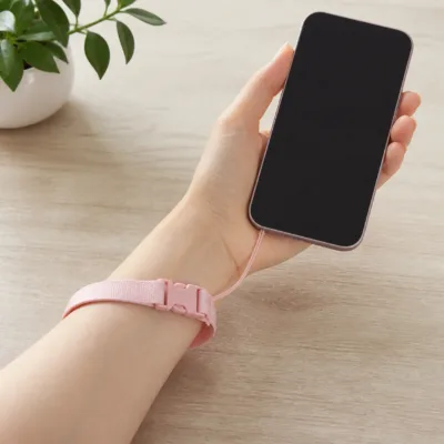 Fita de pulso rosa presa a um telemóvel compatível