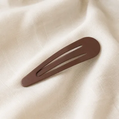 Gancho de cabelo castanho sobre tecido claro