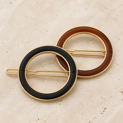 Detalhe dos ganchos de cabelo circulares preto e castanho