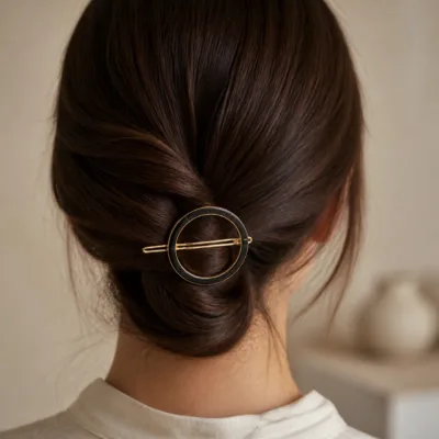 Gancho de cabelo circular preto aplicado num penteado