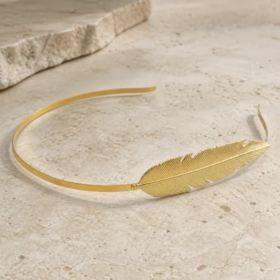 Bandolete dourada com pena decorativa em relevo