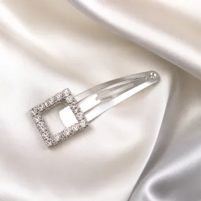 Gancho prateado quadrado com strass sobre cetim
