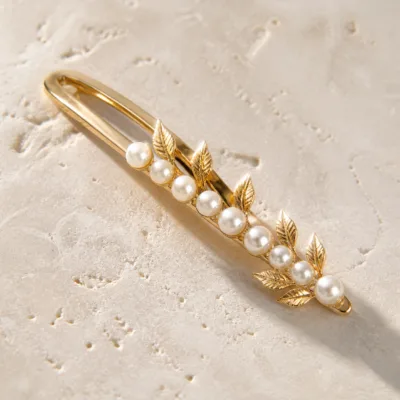 Detalhe das pérolas e folhas do gancho dourado