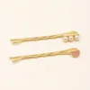 Conjunto de dois ganchos dourados com pérolas e coração rosa
