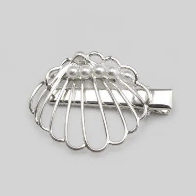 Detalhe frontal do gancho de cabelo concha com pérolas