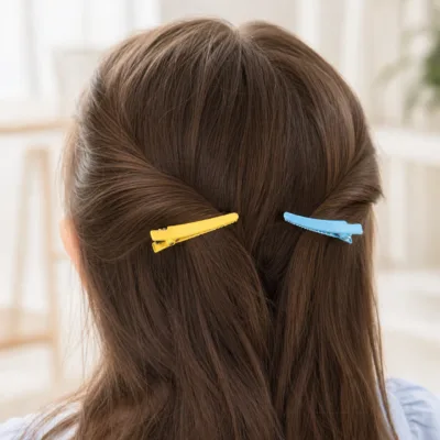 Ganchos bico de pato amarelo e azul aplicados no cabelo