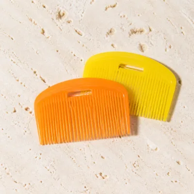 Dois pentes de cabelo coloridos em laranja e amarelo