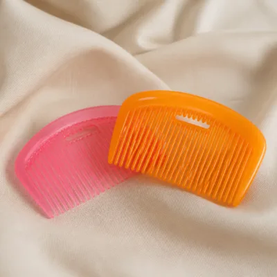 Conjunto de pentes de cabelo rosa e laranja sobre tecido bege