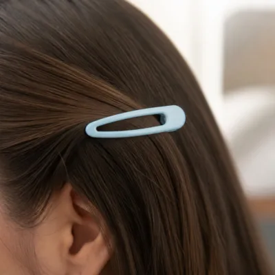 Gancho de cabelo BB azul-claro aplicado numa madeixa