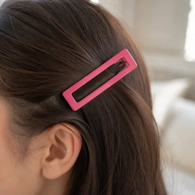 Gancho BB retangular rosa-fúcsia aplicado no cabelo