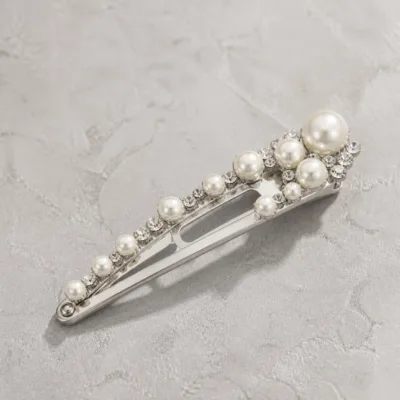 Detalhe das pérolas e do strass no gancho prateado