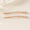Conjunto de dois ganchos rosa-dourado com pérola e cristais