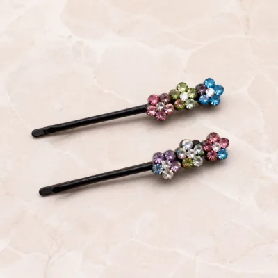 Detalhe de ganchos pretos com cristais rosa azul verde e roxo