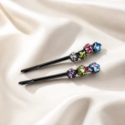 Par de ganchos com flores de cristais multicolor sobre tecido marfim