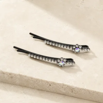 Dois ganchos pretos curvos com cristais transparentes e flor iridescente