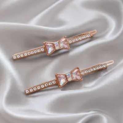 Ganchos com cristais transparentes e laço iridescente sobre cetim