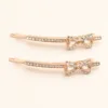 Conjunto de dois ganchos rosa dourado com laço de cristais