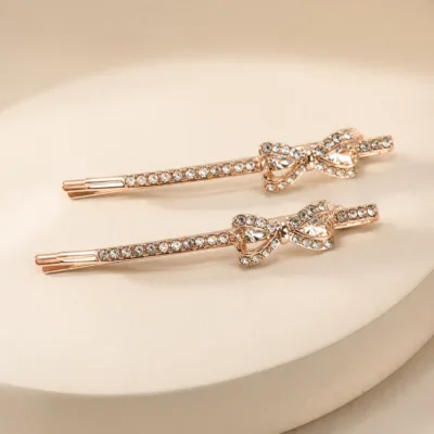 Dois ganchos rosa dourado com laço brilhante