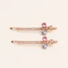 Conjunto de dois ganchos rosa dourado com flor multicolor