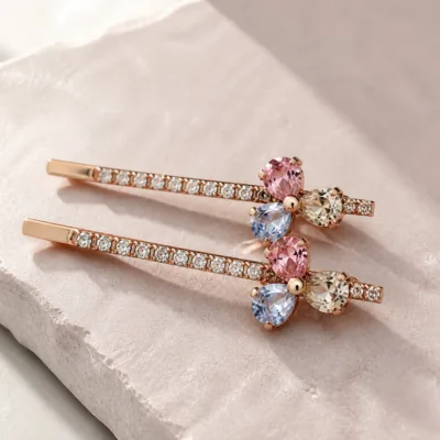 Ganchos rosa dourado com cristais e flor de três pétalas coloridas