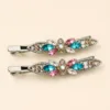 Conjunto de dois ganchos prateados com flor e cristais multicolores