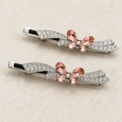 Ganchos largos prateados com laço rosa e ramos de cristais transparentes