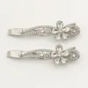 Conjunto de dois ganchos prateados com flor e folhas de cristais