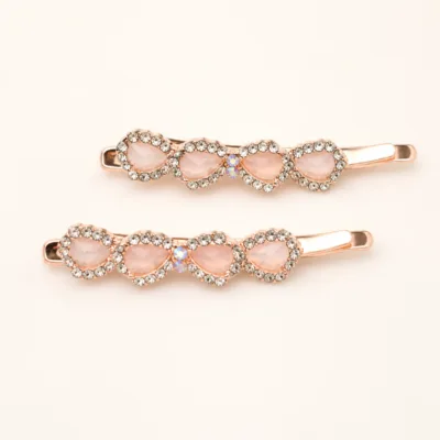 Conjunto de dois ganchos rosa-dourados com resina rosa-pálido e cristais