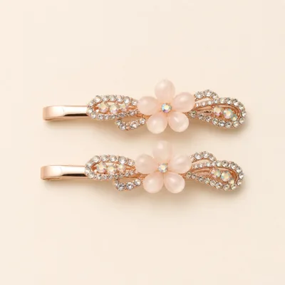 Conjunto de dois ganchos em ouro rosa com flor branca e cristais
