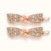 Conjunto de dois ganchos ouro rosa com laço de cristais e centro coral