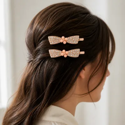 Dois ganchos ouro rosa com laço de cristais aplicados no cabelo