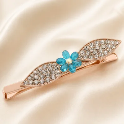 Detalhe de gancho ouro rosa com folhas de cristais e flor turquesa