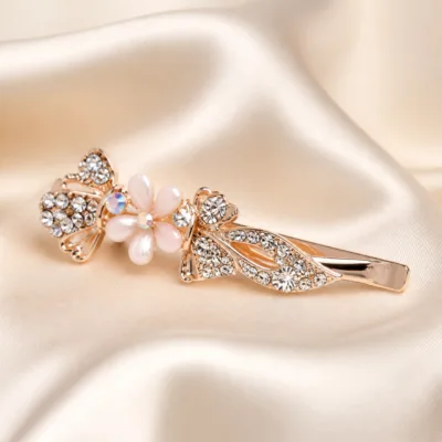 Detalhe de gancho ouro rosa com borboleta brilhante e flor rosa-claro