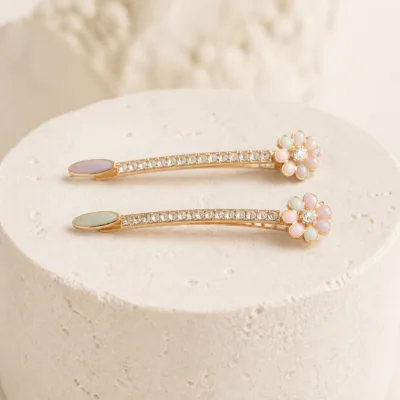Dois ganchos ouro rosa com flores multicolores sobre pedra clara