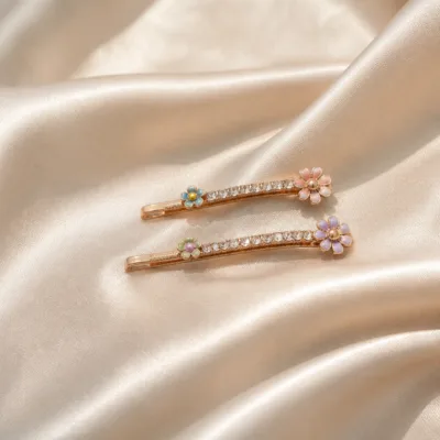 Conjunto de ganchos ouro rosa com flores coloridas sobre cetim