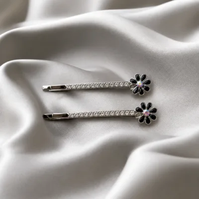 Conjunto de ganchos prateados com flores coloridas sobre cetim