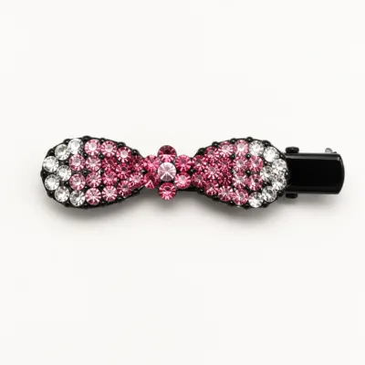 Gancho de cabelo preto com laço de strass rosa em fundo branco