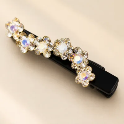 Detalhe das flores de strass iridescente no gancho preto