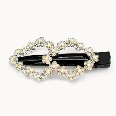 Gancho preto com duas flores de strass branco em fundo claro