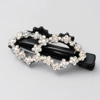 Detalhe do gancho preto com duas flores abertas de strass