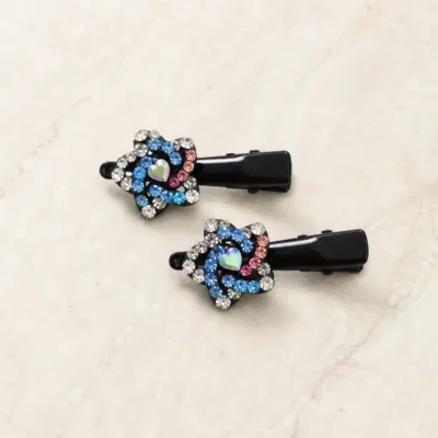 Dois ganchos pretos com motivo floral de strass sobre pedra clara