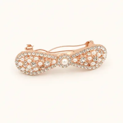 Gancho automático rosa-dourado com pérolas e strass em fundo branco